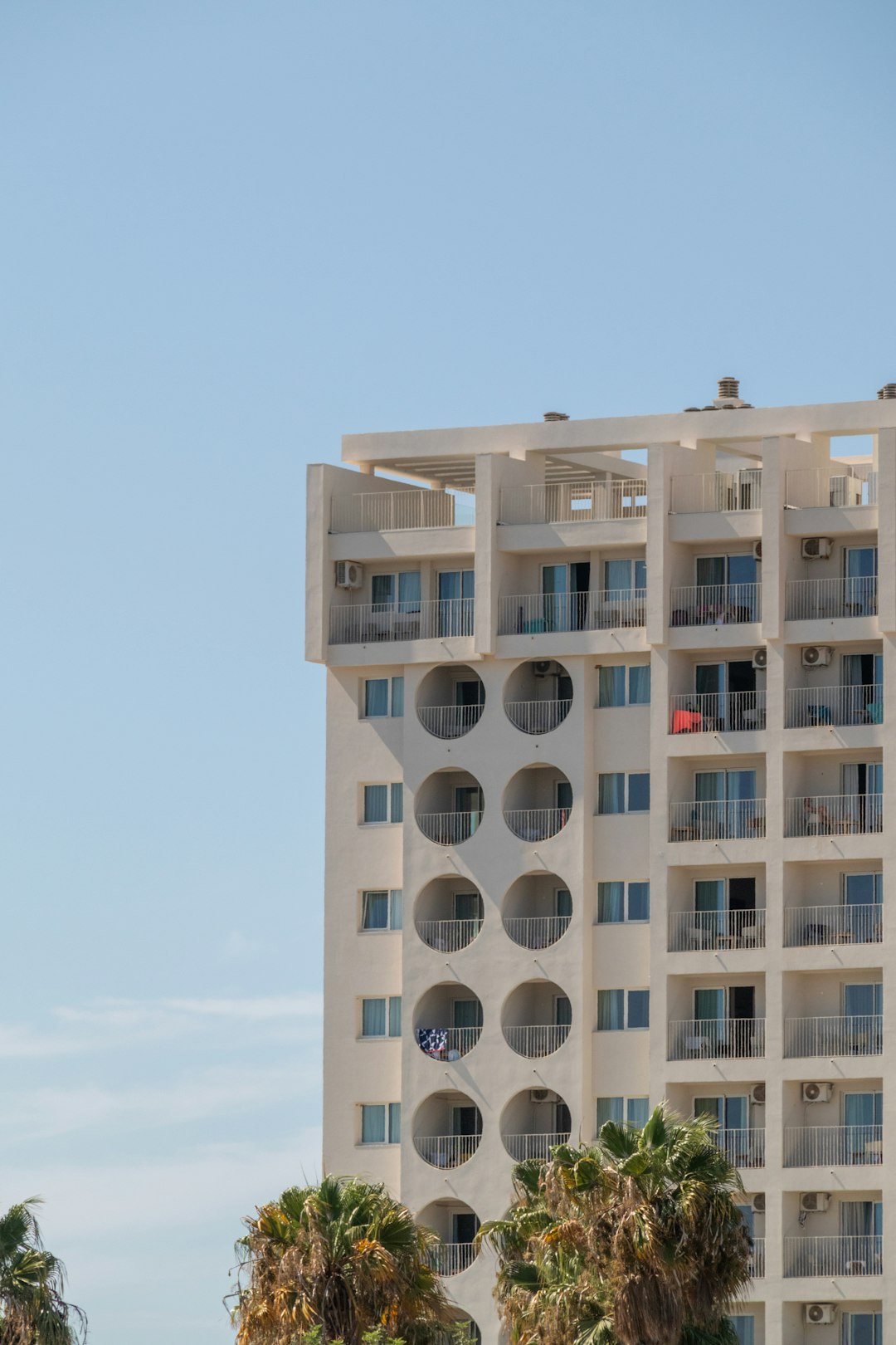 services-04 a-tall-white-building-with-balconies-on-the-top-of-it-nolcalpqcfw